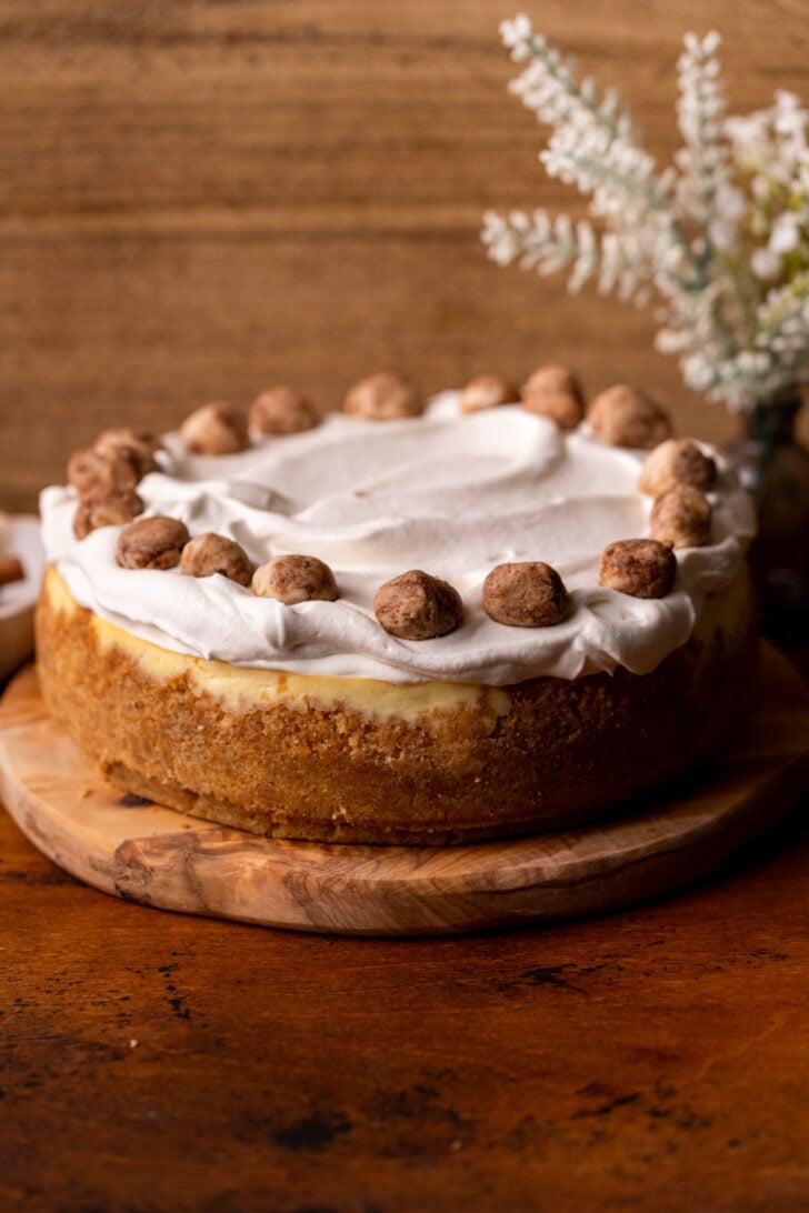 Decorated cheesecake on a wood board.