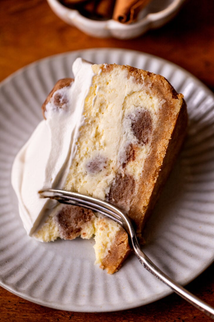One slice of cheesecake on a plate on it's side.