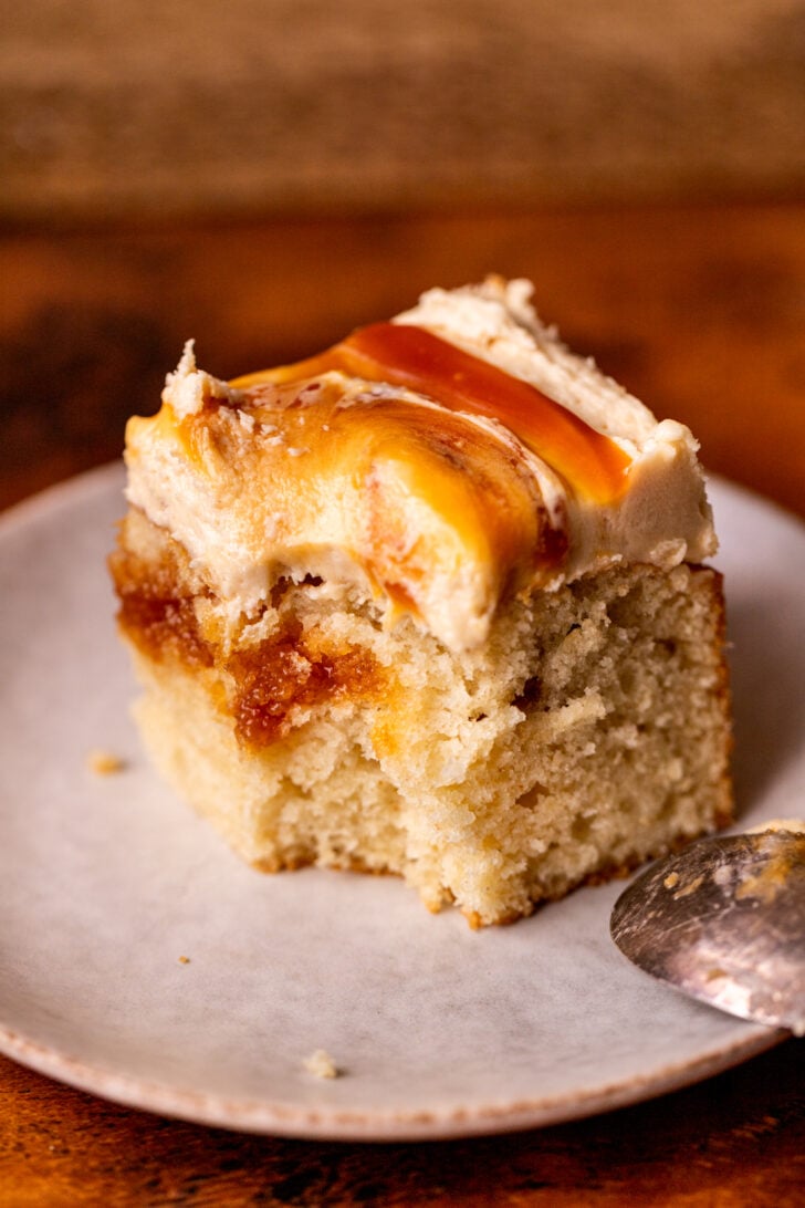 Bite missing from a cake on a plate.