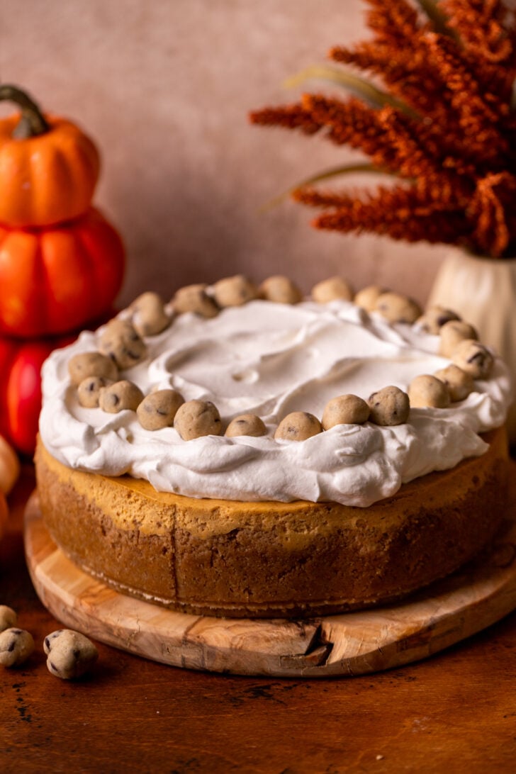 Decorated cheesecake on a wood board.