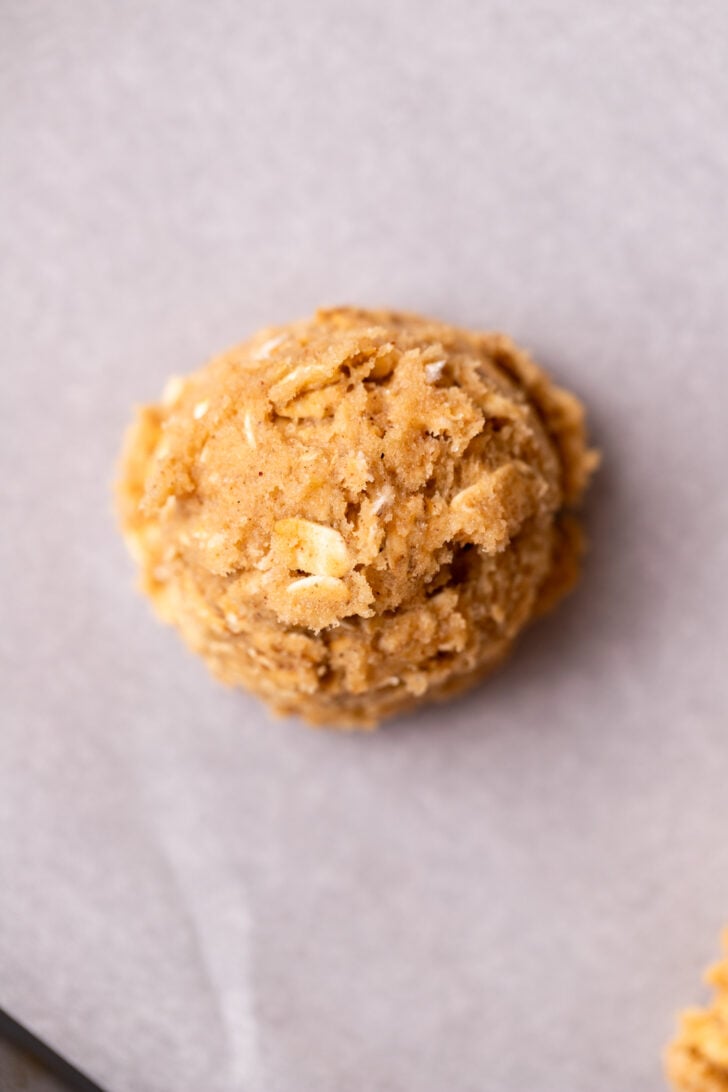 Cookie dough ball on parchment paper.