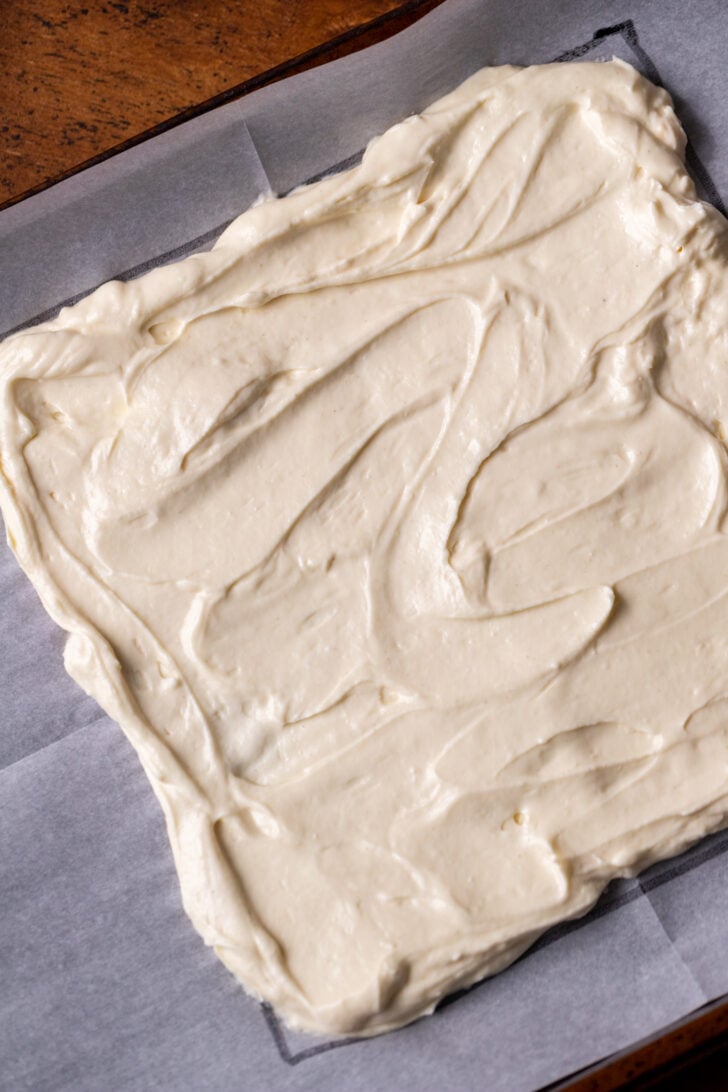 Cheesecake filling spread on parchment paper.