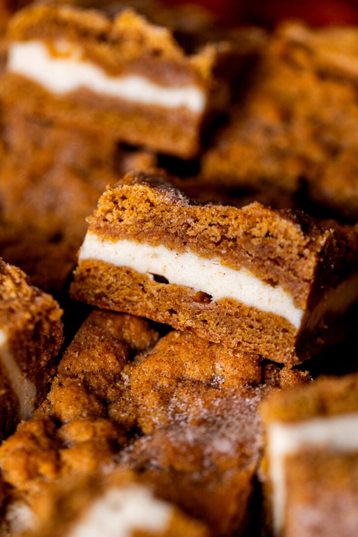 One slice of pumpkin cheesecake cookie bars on its side close up.