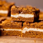 Stack of three pumpkin cheesecake cookie bars.