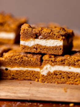 Stack of three pumpkin cheesecake cookie bars.