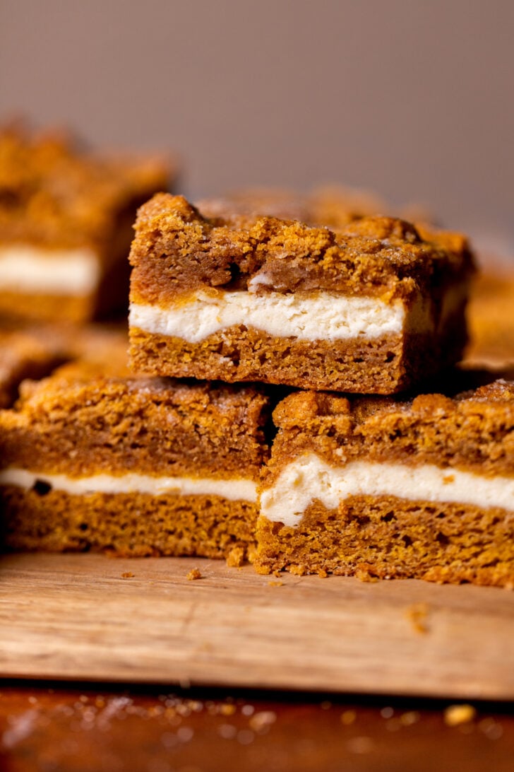 Stack of three pumpkin cheesecake cookie bars.
