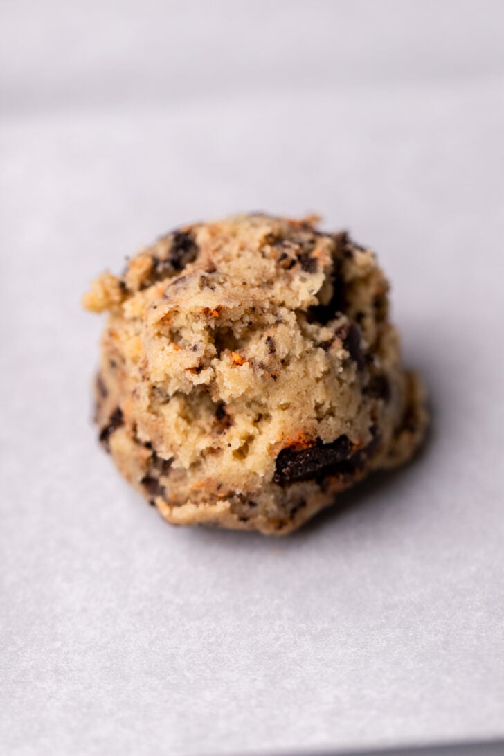 Cookie dough ball on parchment paper.