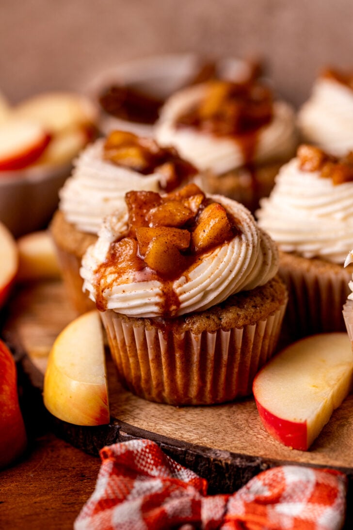 One apple pie cupcake on a wood board.
