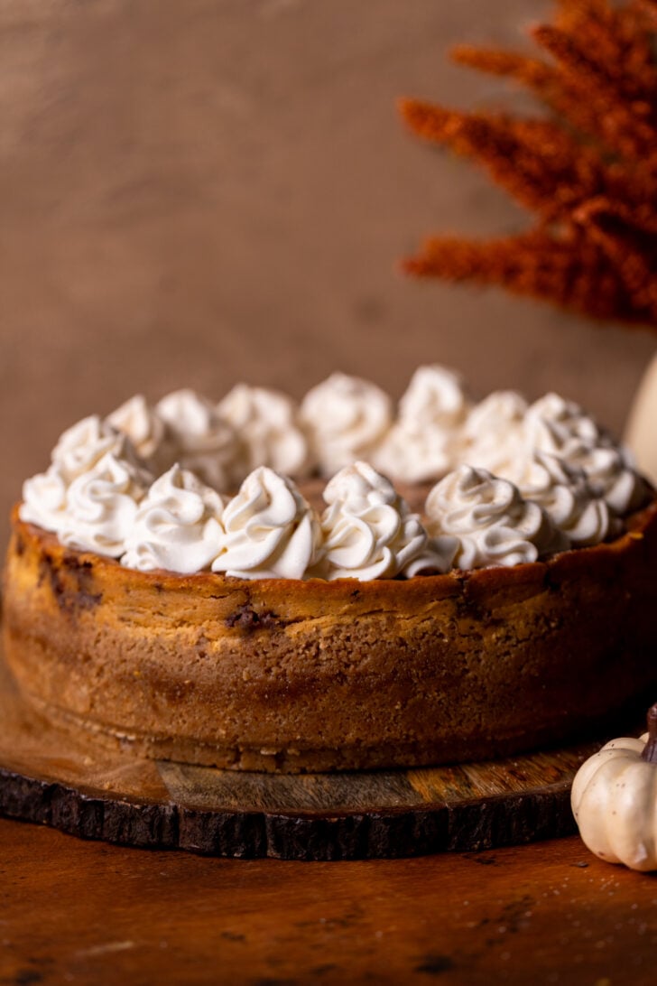 Decorated cheesecake on a wood board.