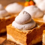 Whipped cream dollop on top of cheesecake bar.
